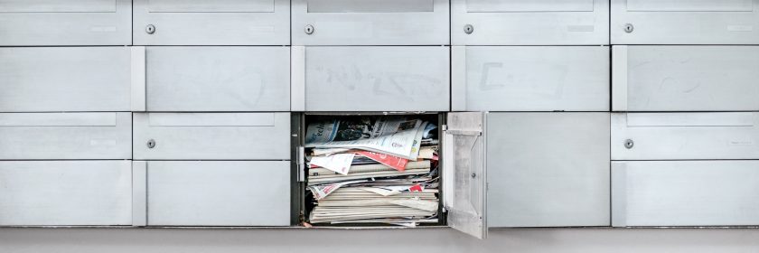 A mail box overflows with newspapers, letters, and more, likely because mail forwarding or address changes weren't set up before moving in Ottawa.