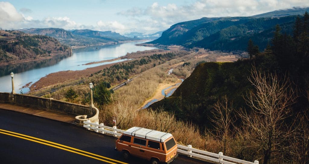 The Most-Forgotten Things During Long-Distance Moves 6 A van sits parked on the side of a road looking over a beautiful river valley, possibly with a driver trying to find something they forgot at the start of their long-distance move.