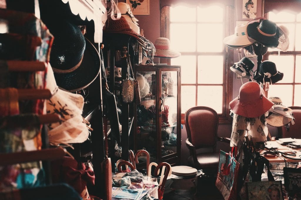 The First Step When Moving? Declutter! 3 A wide selection of hats clutters a room, on all shelves and surfaces, obviously not adhering to minimalism.