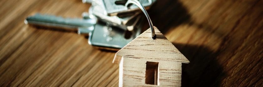 wooden house keychain with four keys on it