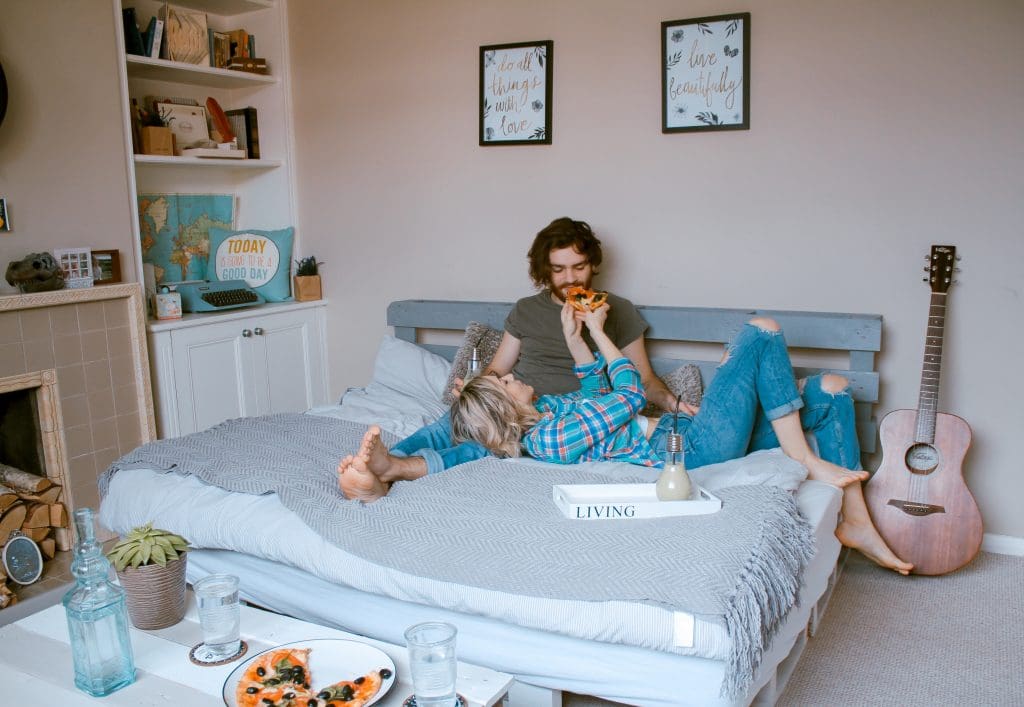 7 Major Benefits of Using a Moving Company 2 Couple eats pizza in bed